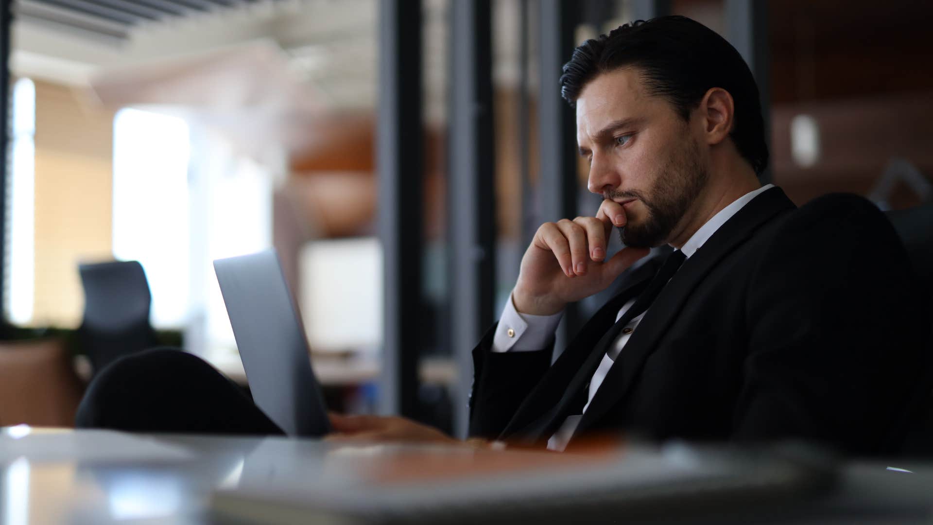 serious businessman looking at laptop