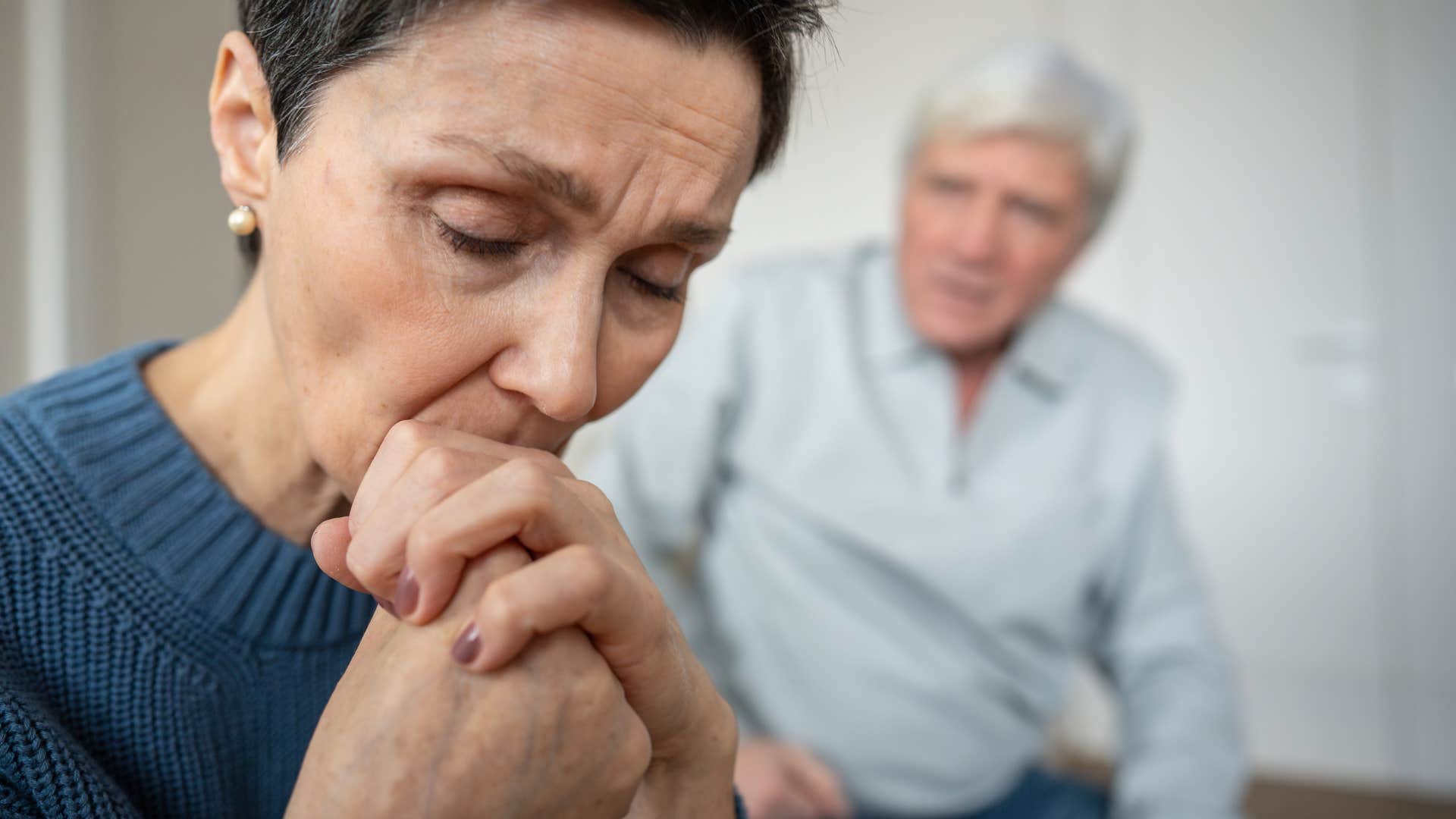 wife turned away from husband looking sad