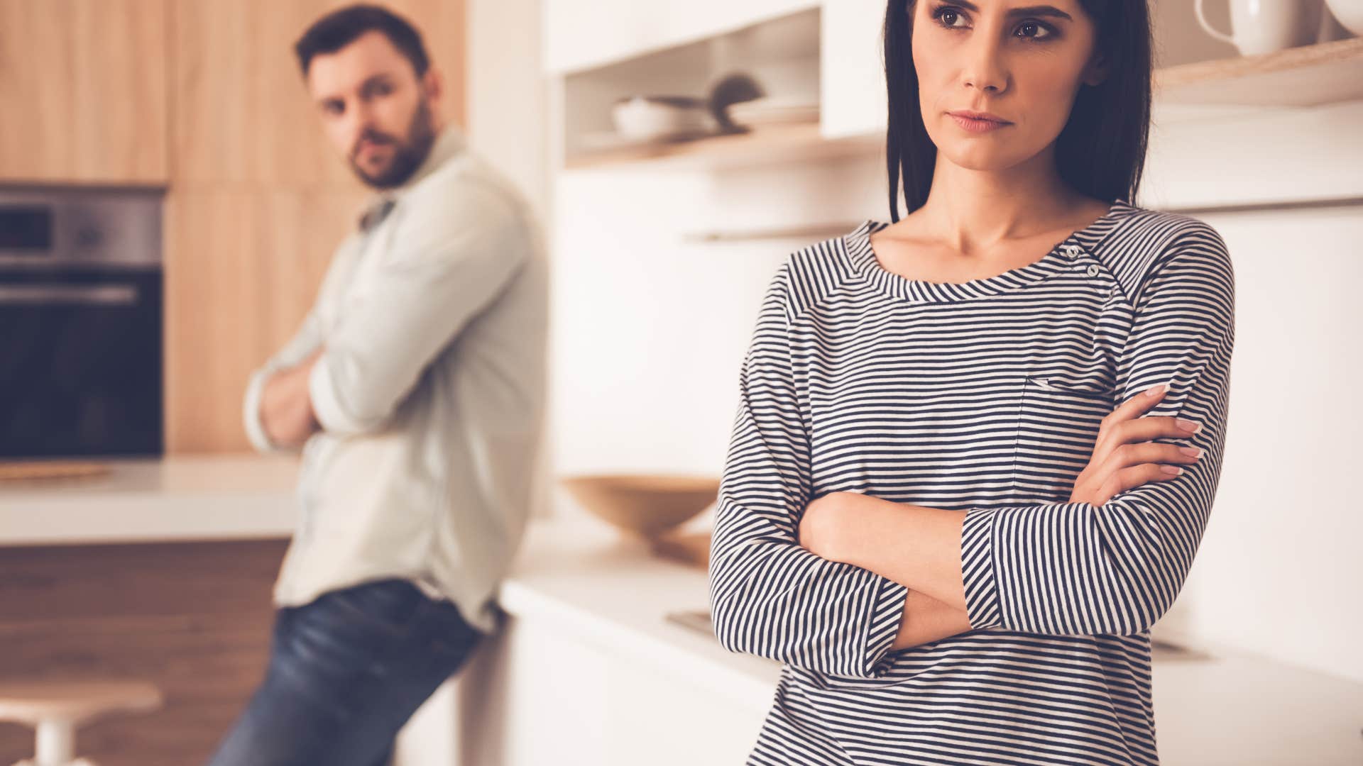 couple growing distant standing in kitchen together