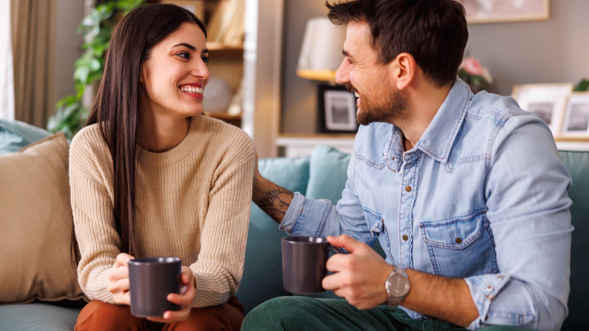 happy couple sitting on couch together husband paying attention to the little details