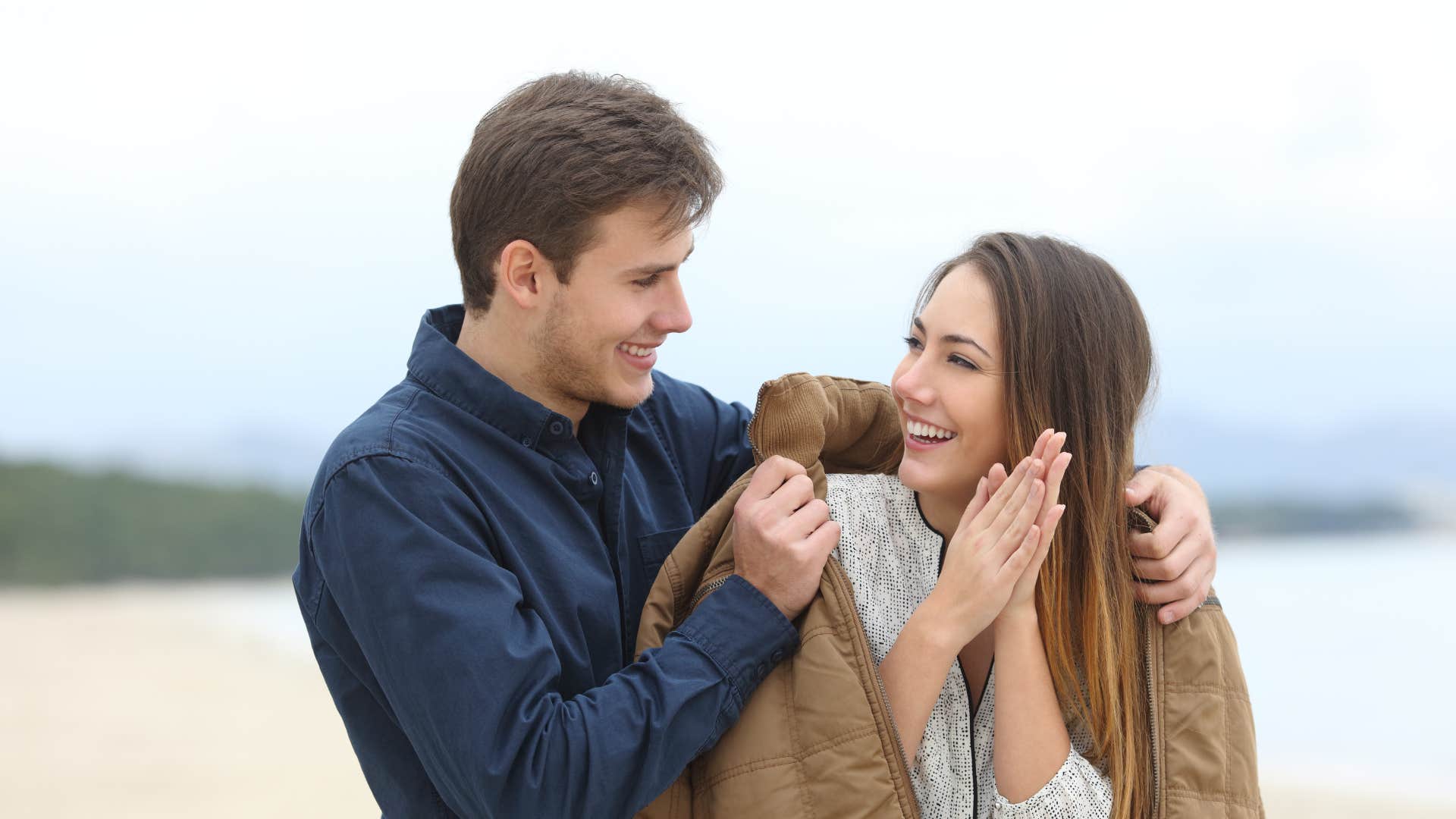 man helping his partner put on her jacket