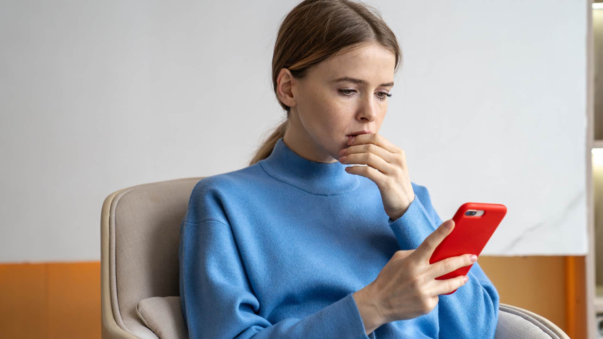 woman who has a fear of missing out looking at her phone