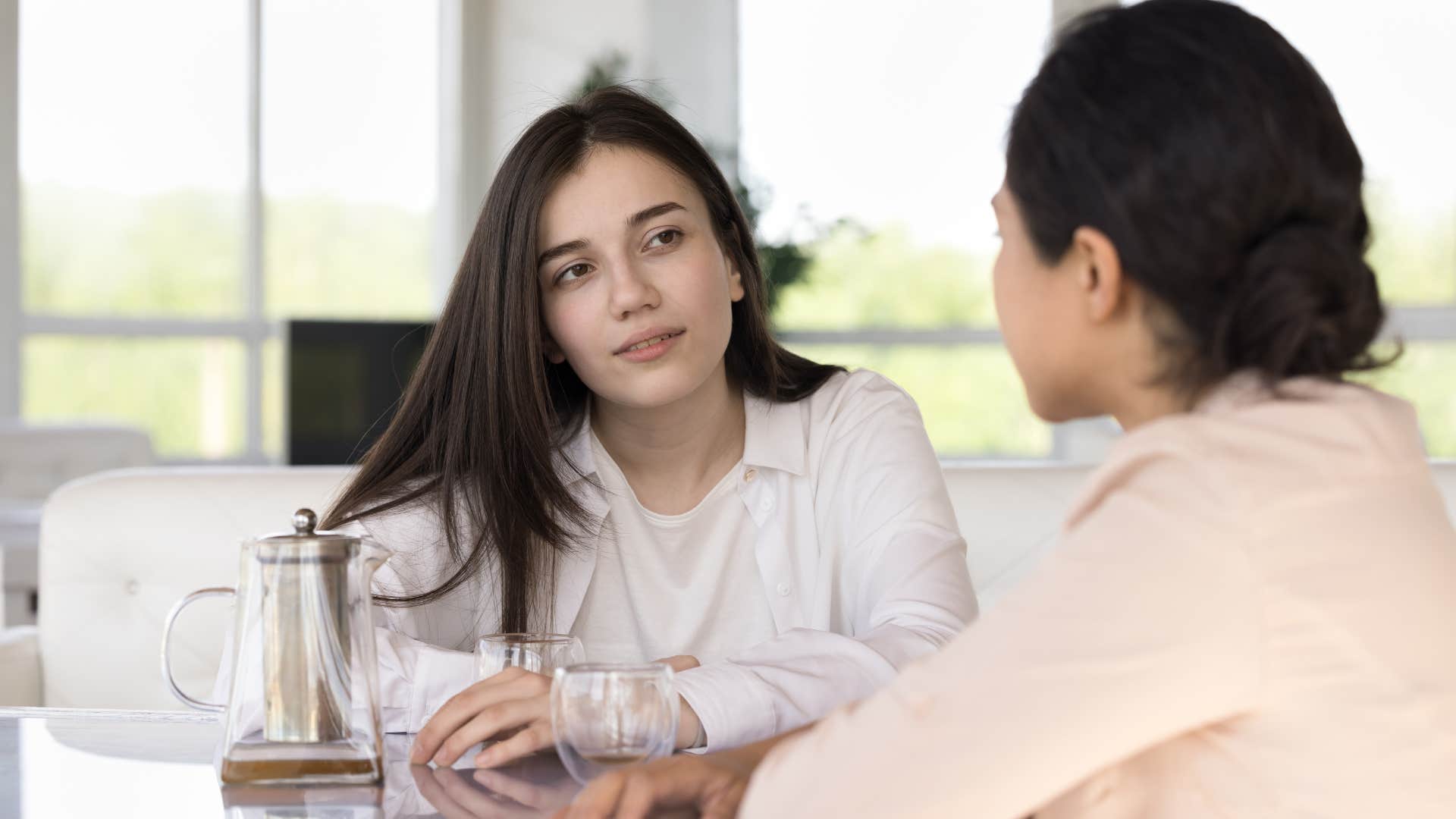 woman listening to friend talk sitting at table