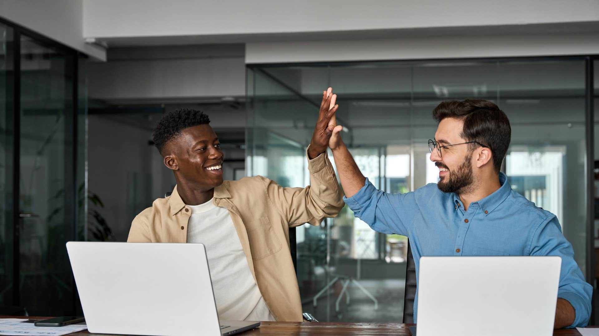 two men high-fiving in office