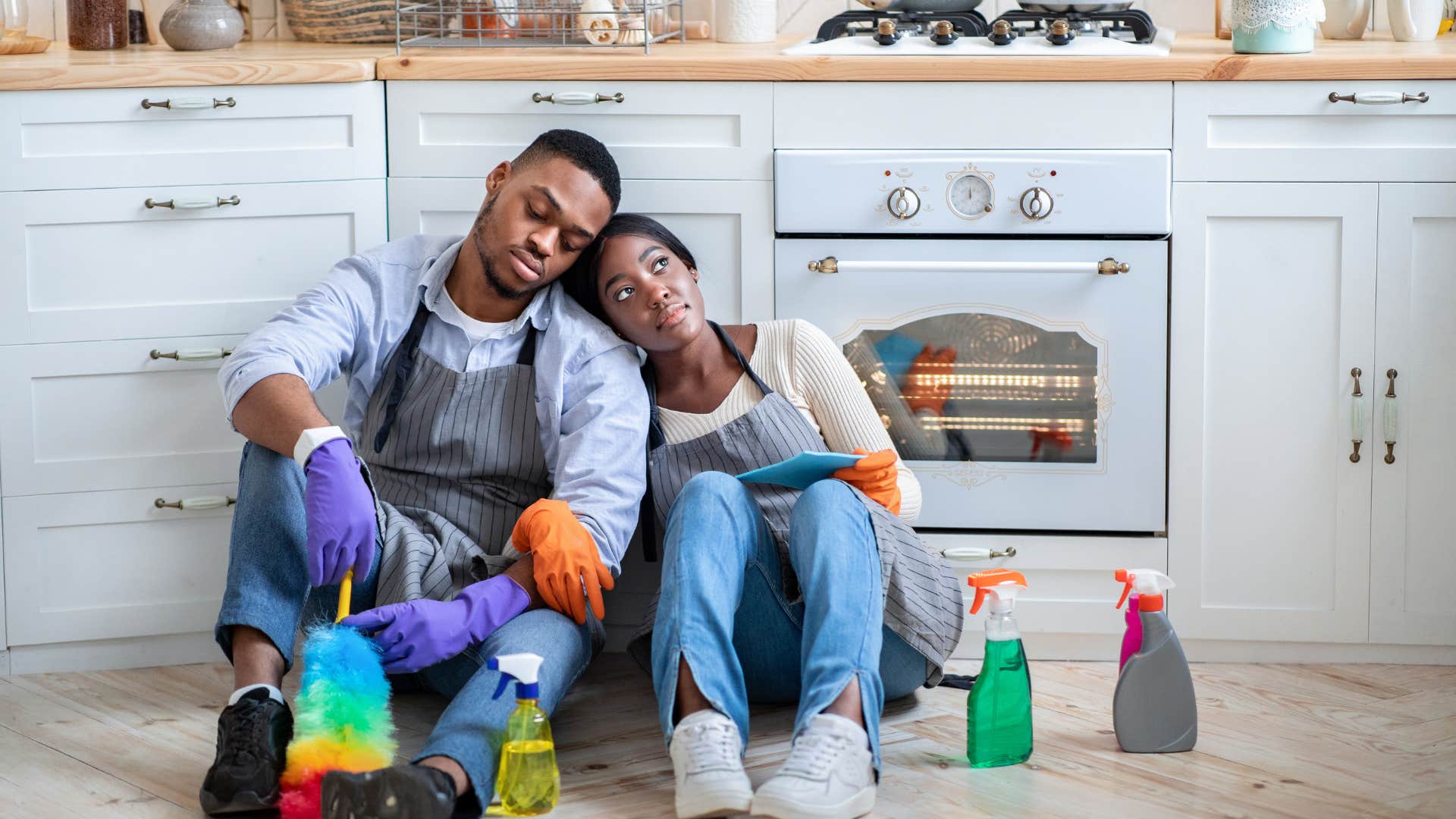 couple surrounded by cleaning supplies