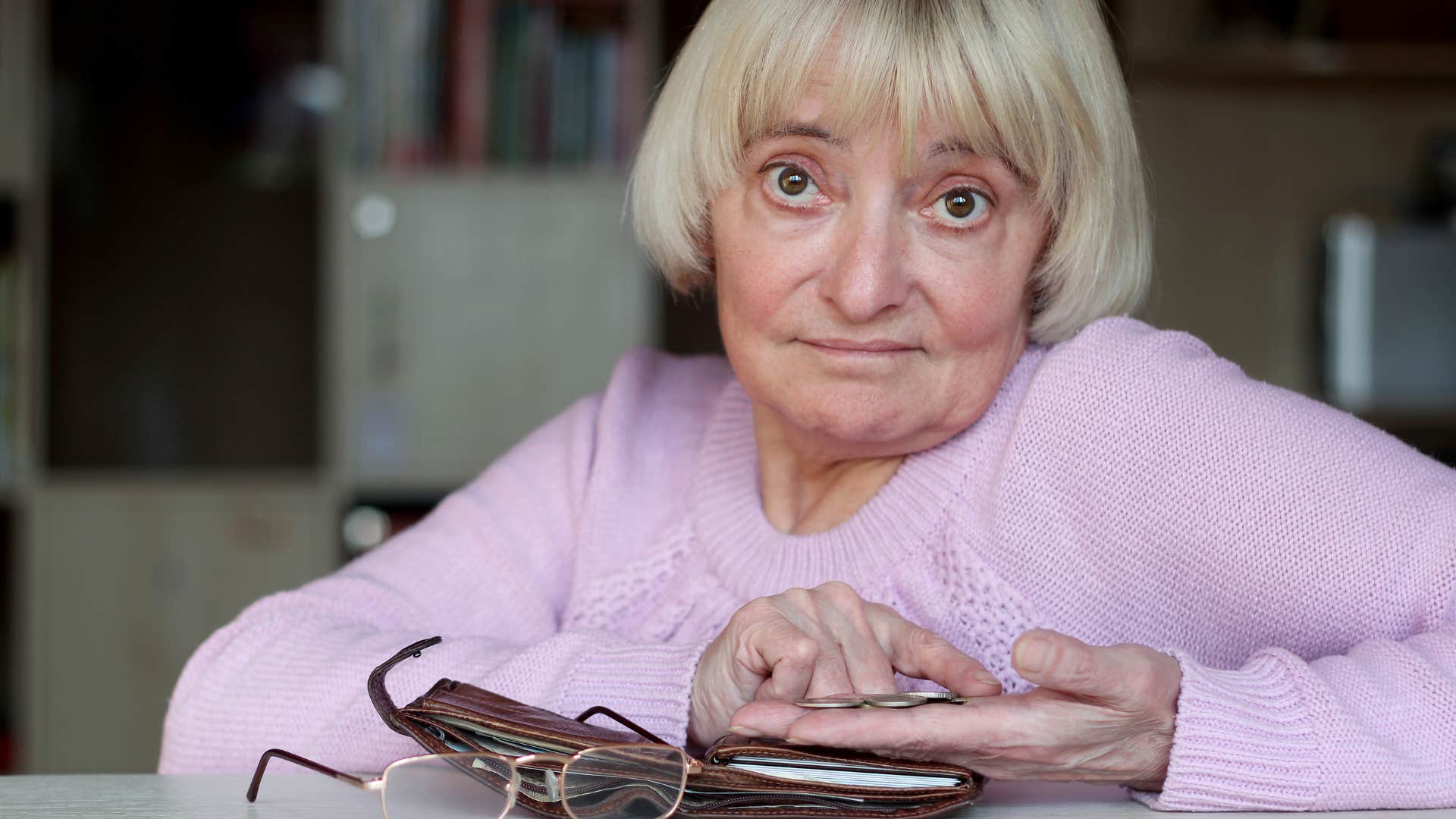 woman sitting at her counter with her wallet