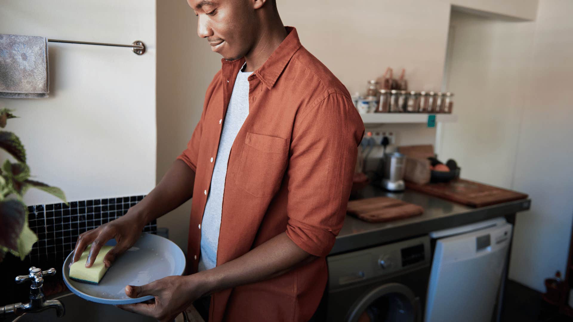 man hand-washing dishes