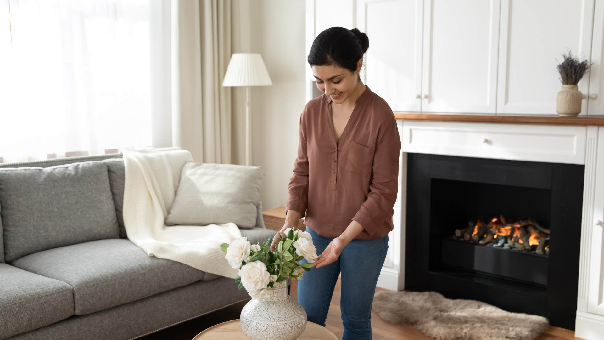 woman rearranging flowers in living room