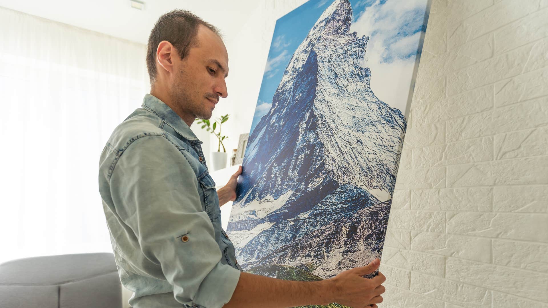 man hanging picture frame