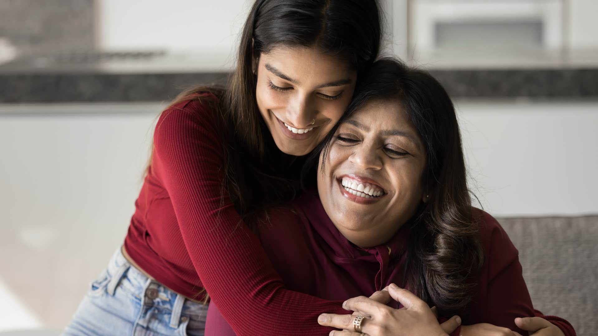 mom hugging adult daughter