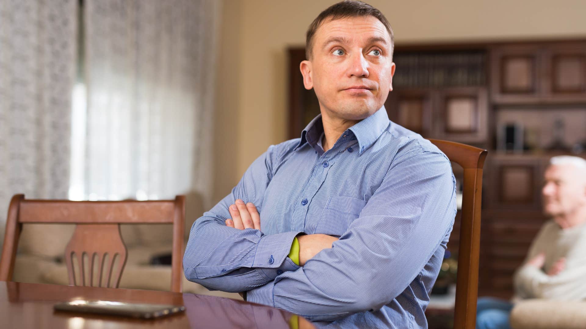 Annoyed man saying "you could've helped me sooner" at home.