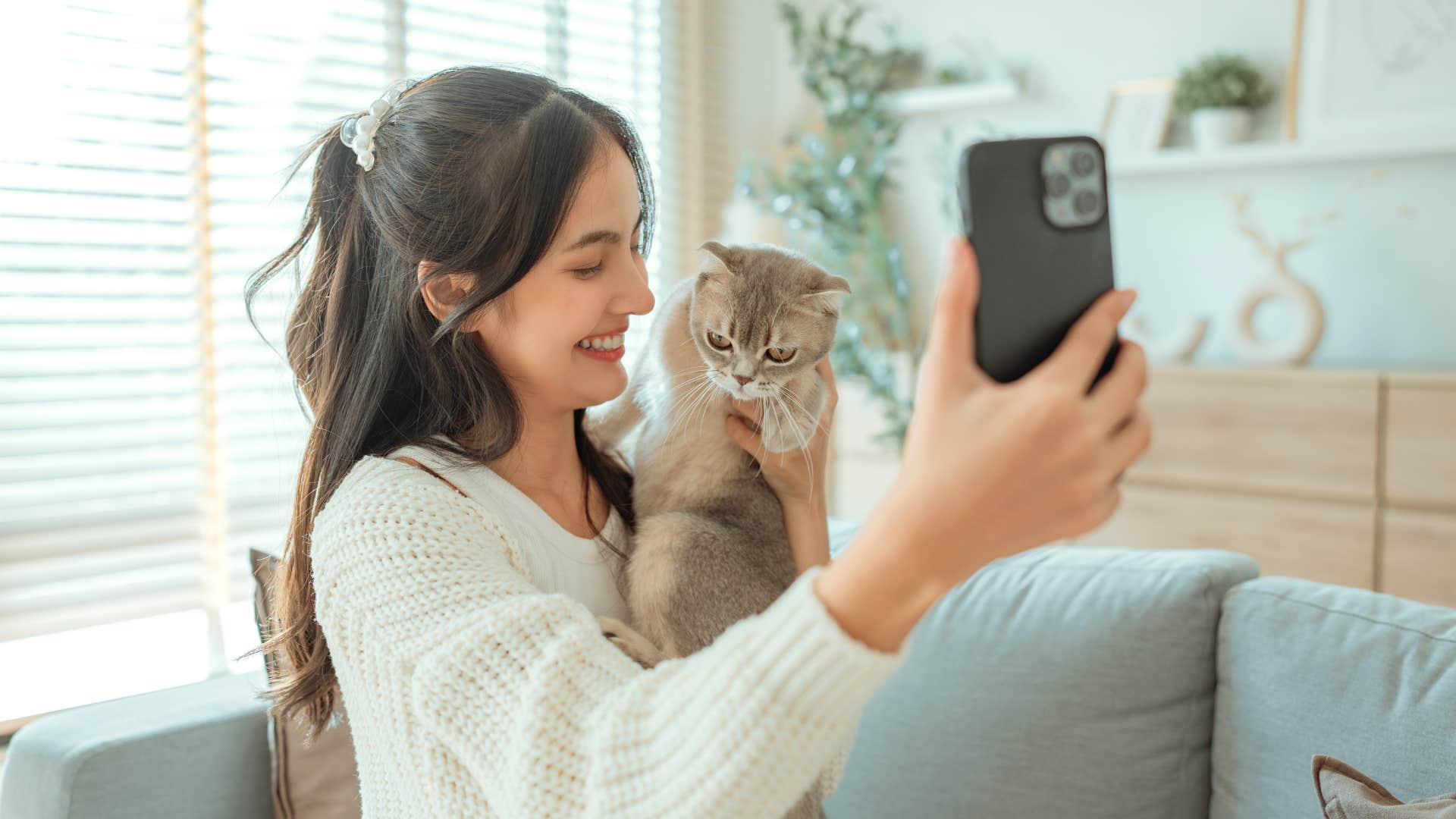 woman taking photo with her cat
