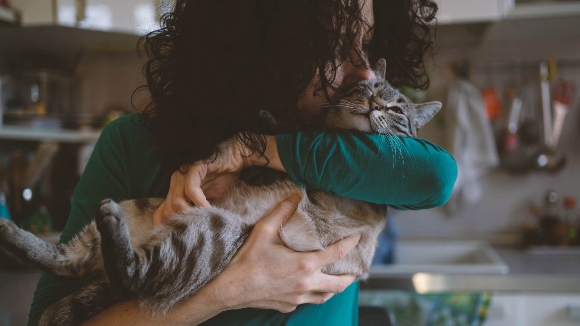 woman kissing cat snuggling