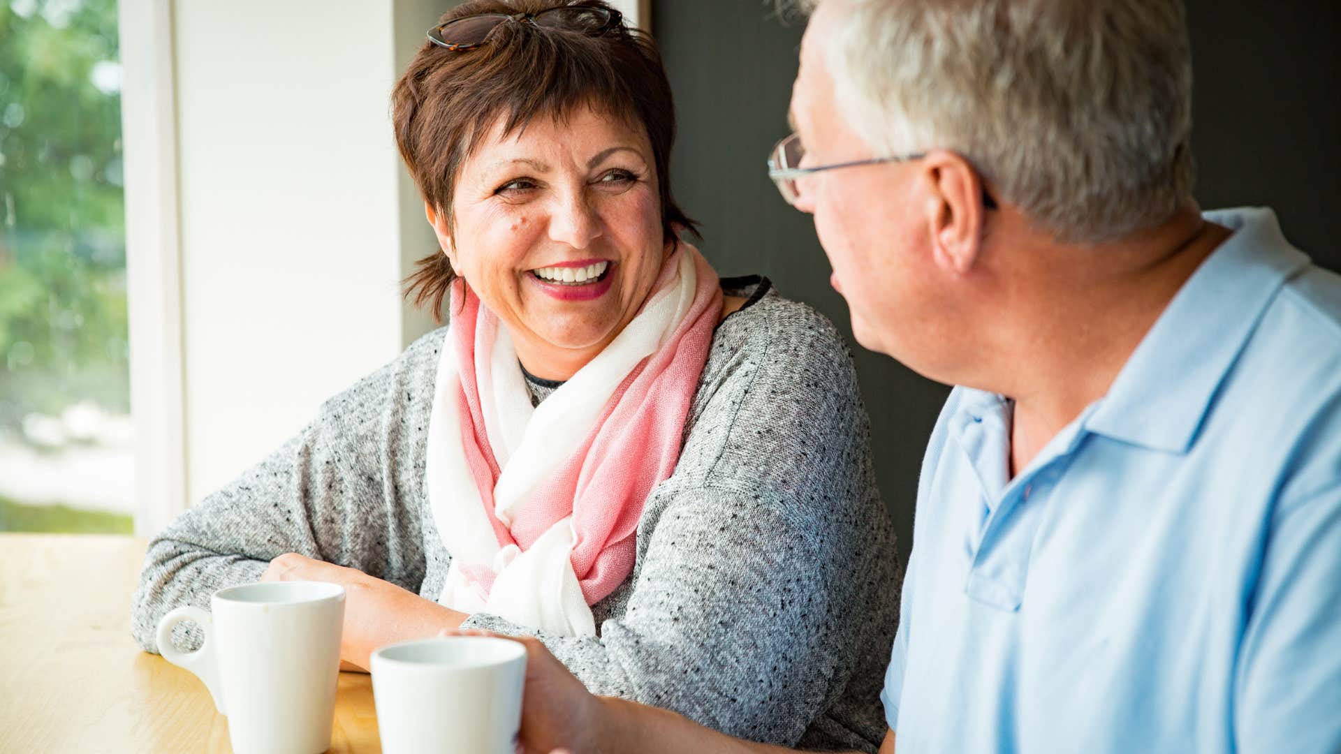 older man who seems more energized when company is around talking to his wife
