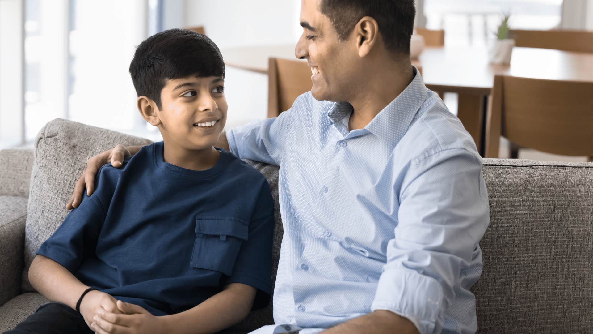 father with his arm around his young son