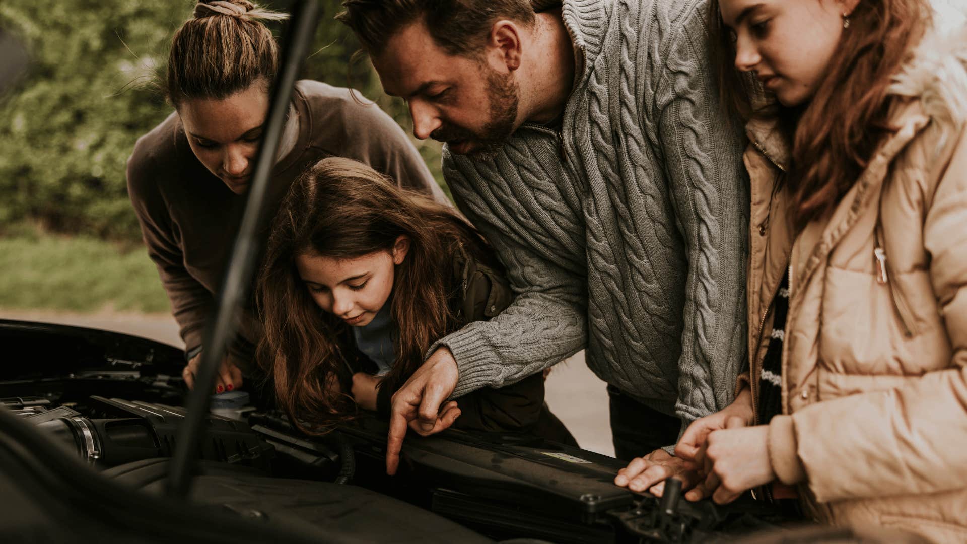 father teaching kids about car maintenance