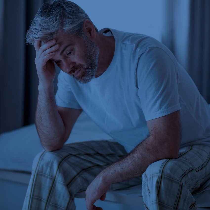 unhappy man sitting up in bed being avoidant disconnected and passive