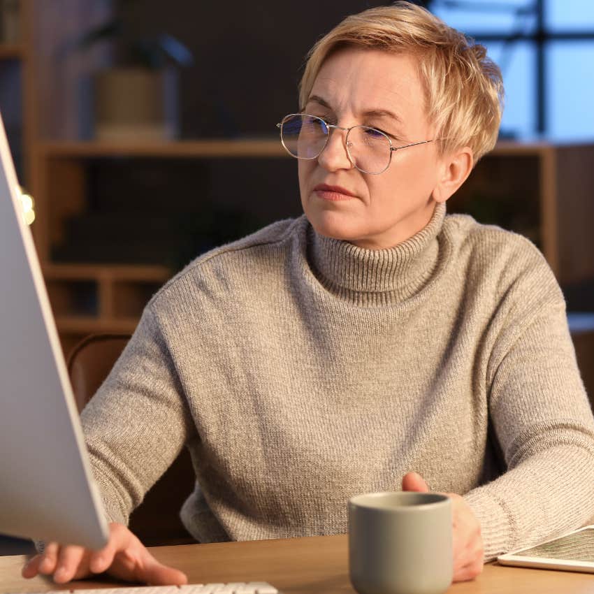 older lonely woman staying up late working on her computer