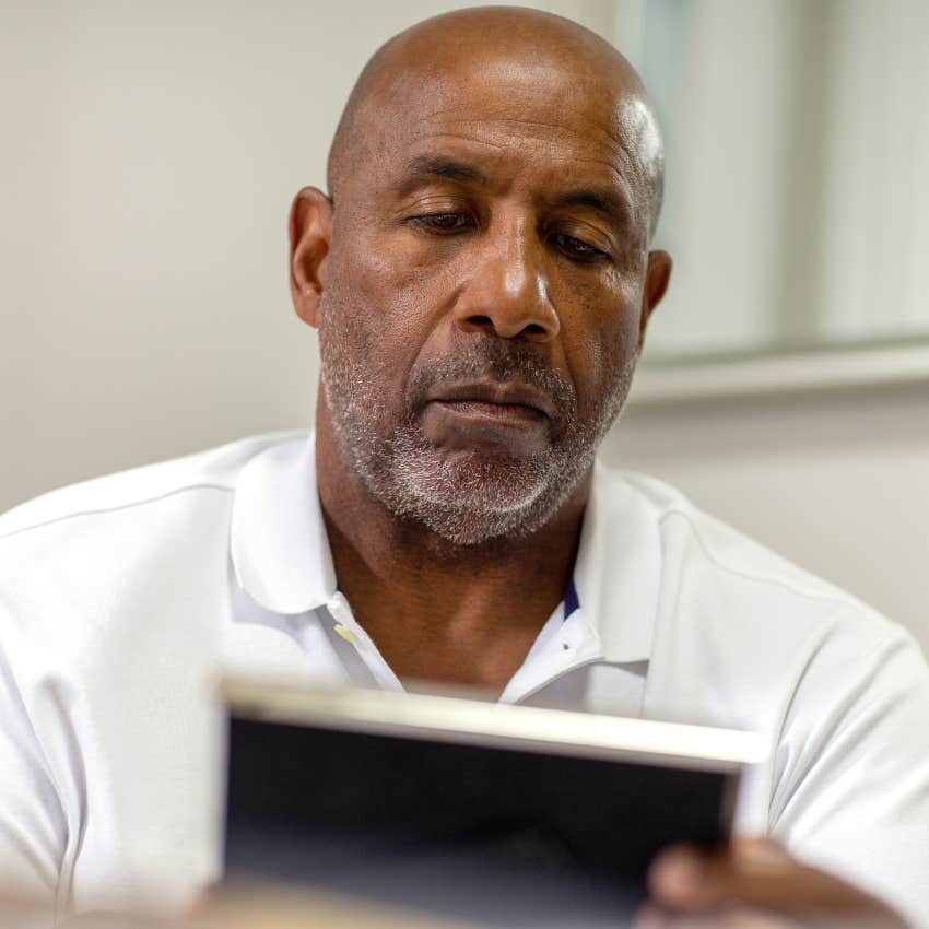 overly sentimental man looking at photograph