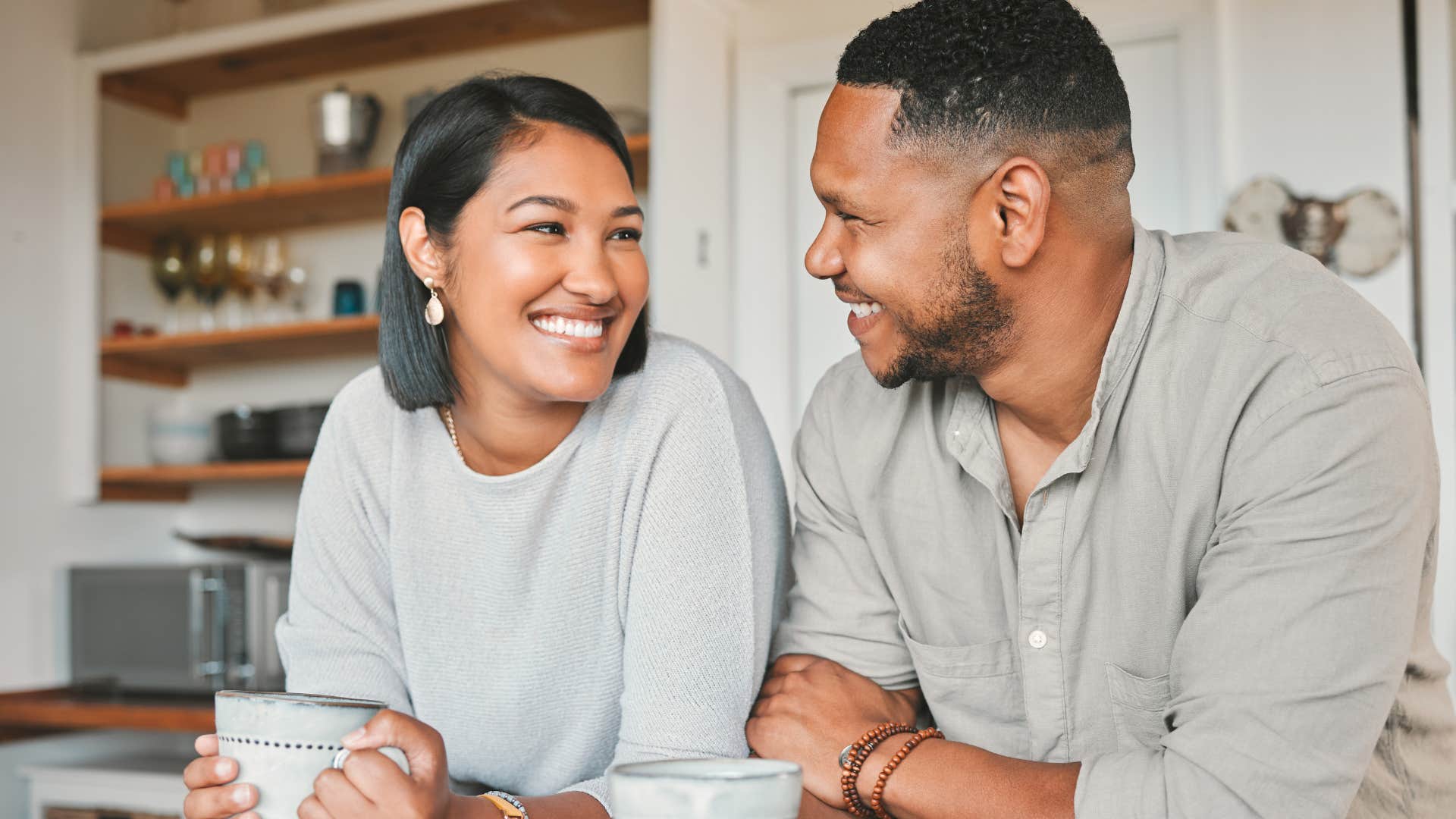 couple smiling over coffee woman telling husband I love you so much