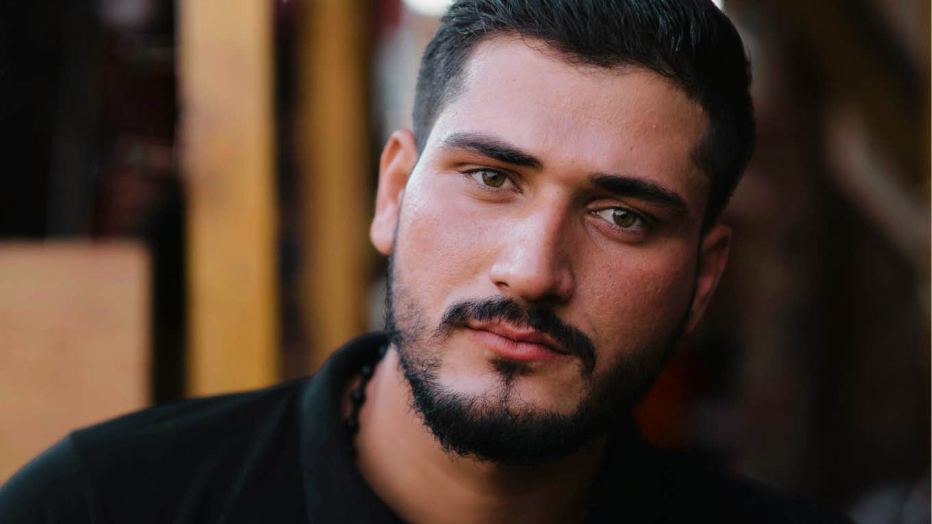 Man with a guilty distant expression, illustrating the signs a man is probably going to cheat on you again.