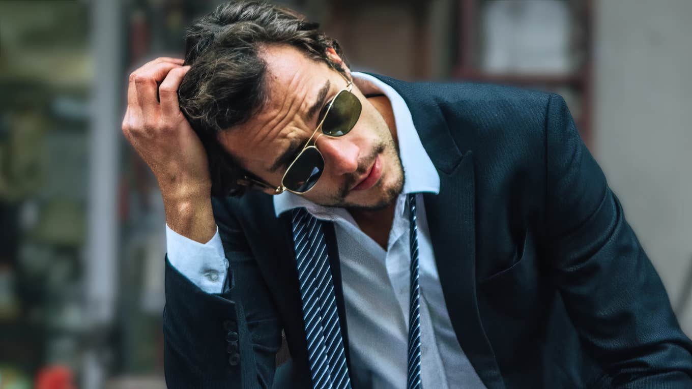 Distant man in a suit looking overwhelmed and disconnected, illustrating the telltale behaviors of men who will never be your person no matter how hard you love them.