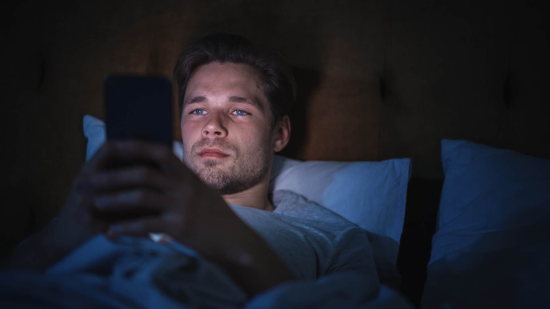 man late-night texting from bed