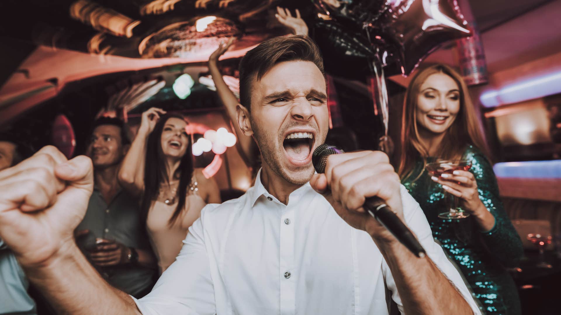man with single friends out late doing karaoke