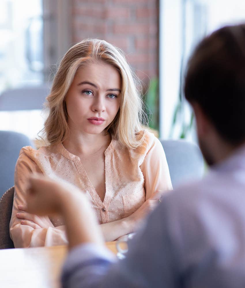 Annoyed woman looks at clingy man showing he is moving too quickly