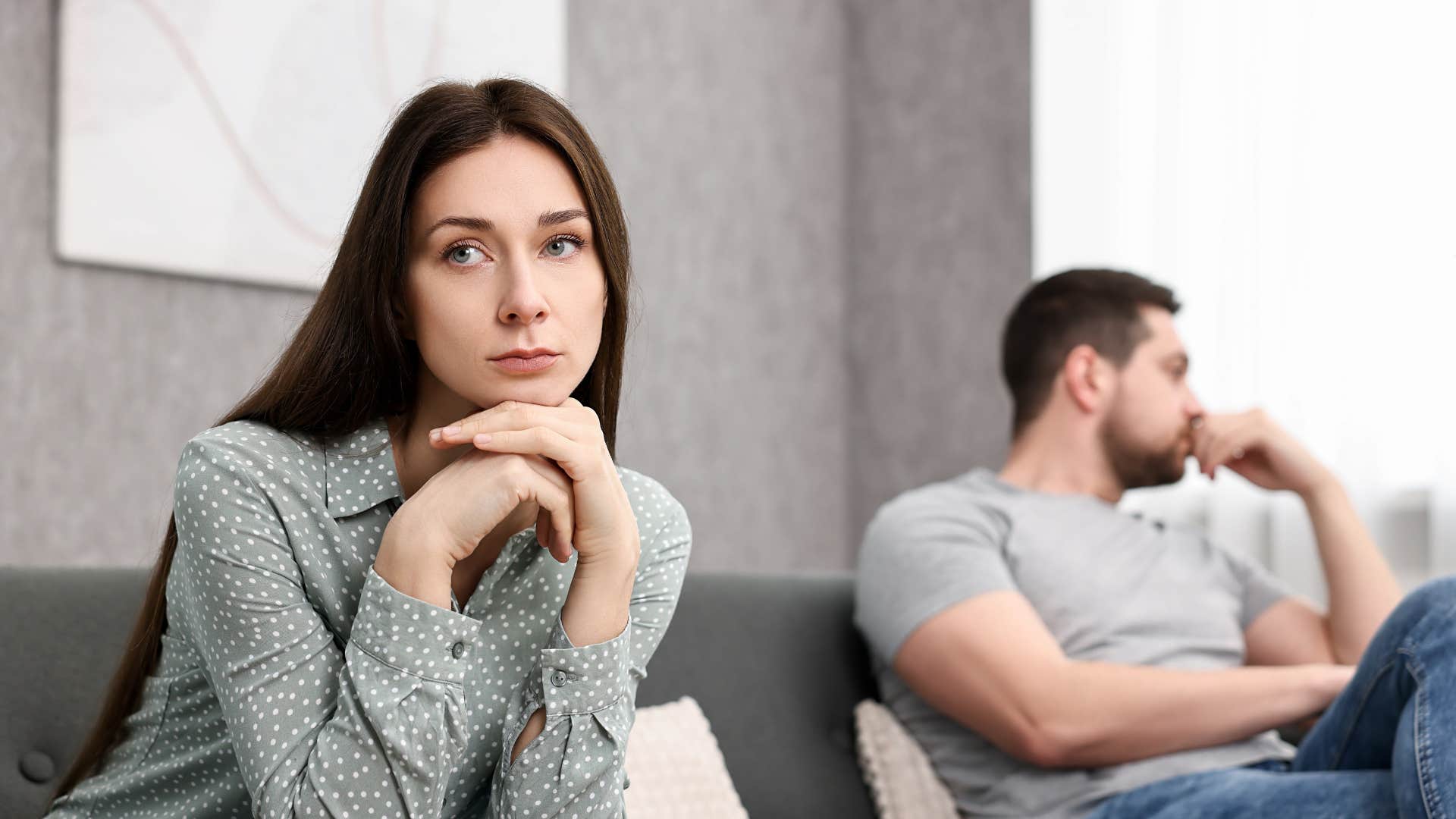 couple avoiding eye contact sitting far apart