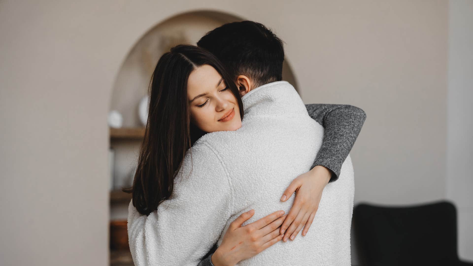 unhappy couple awkwardly hugging