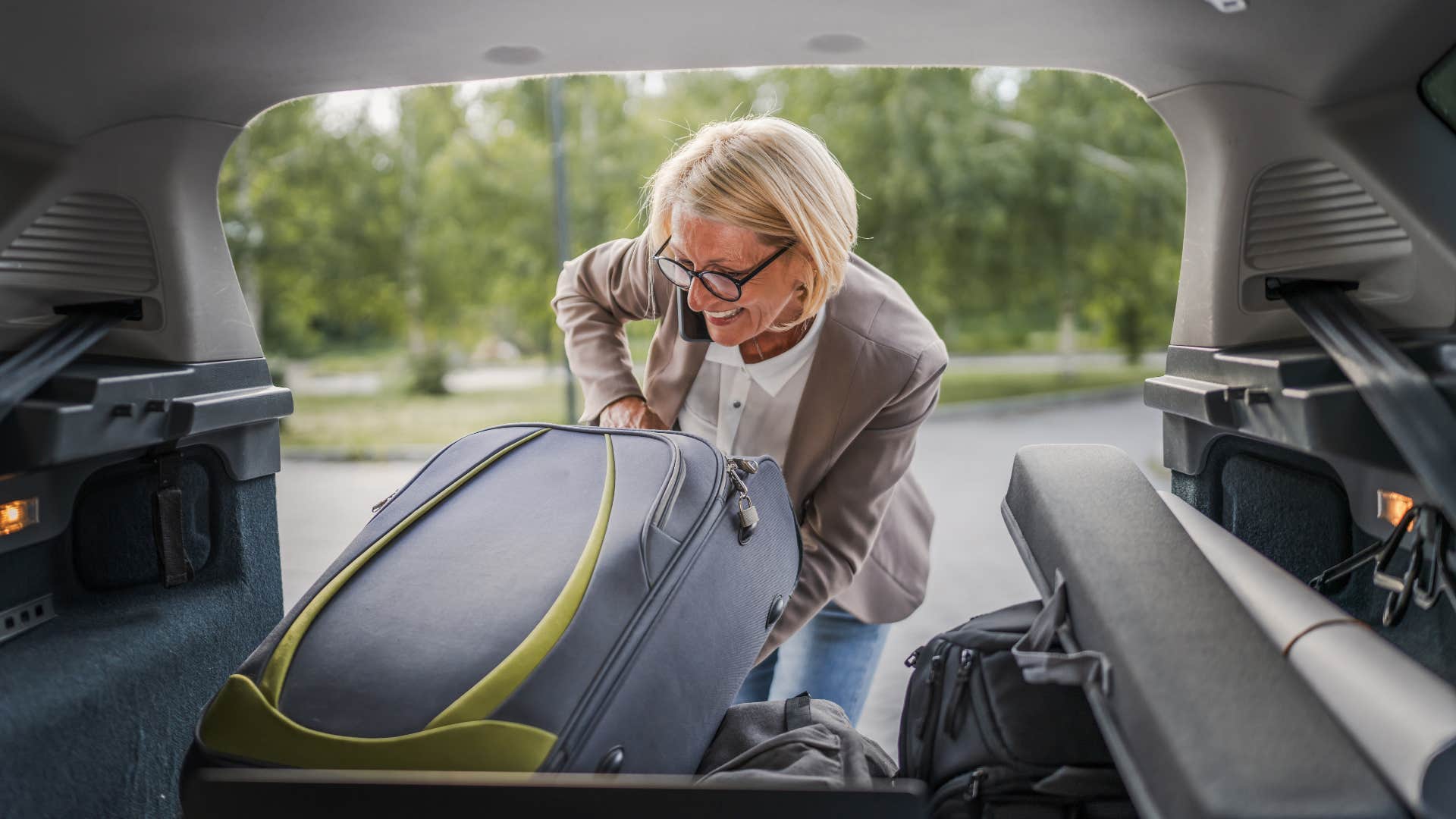 woman cleaning out backseat full of random items