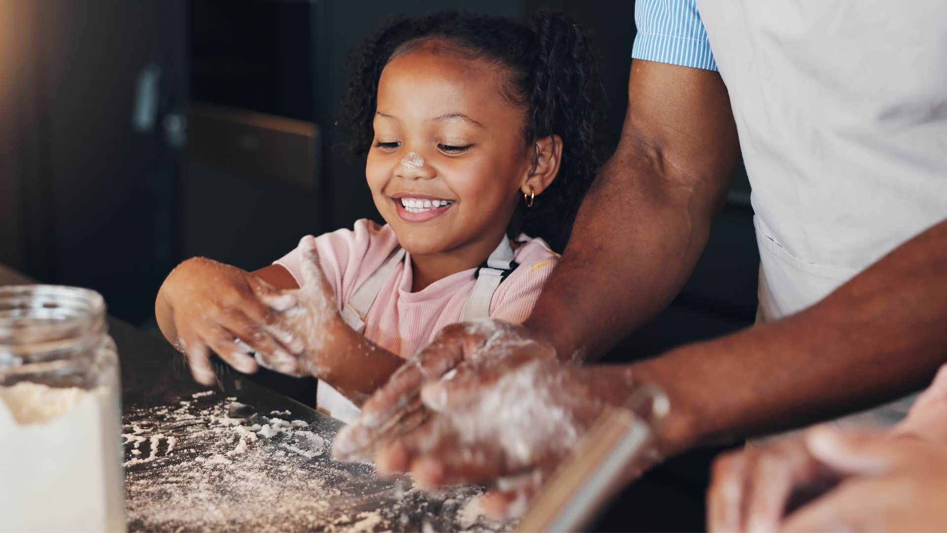 Little girl with parents teaching her to cook basic meals.