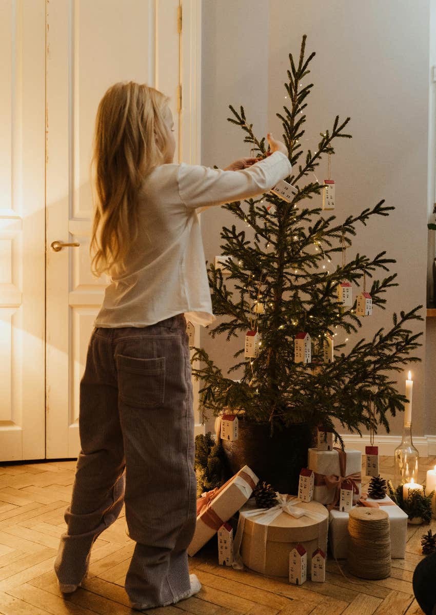 kid decorating a Christmas tree