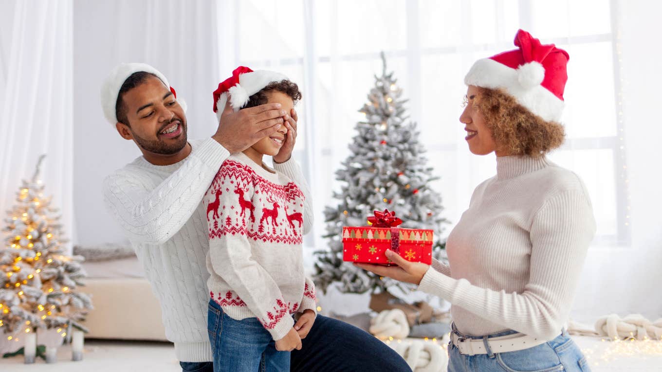 parents giving their kid a gift on Christmas