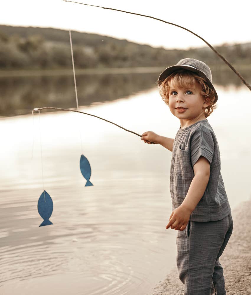 Excited young child fishing showing present to make kid happy