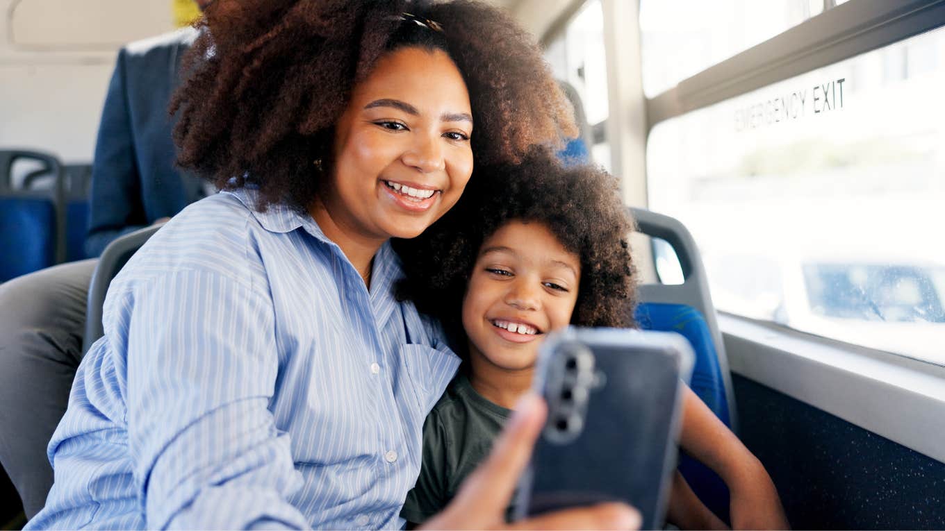 mom taking a selfie with her son on the bus