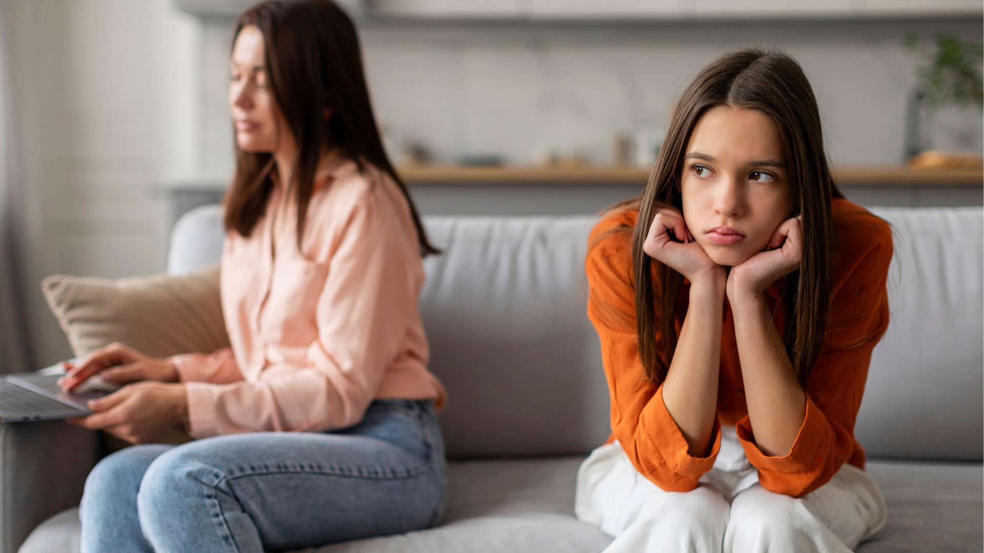 mom on her phone sitting next to daughter she feels she needs to control
