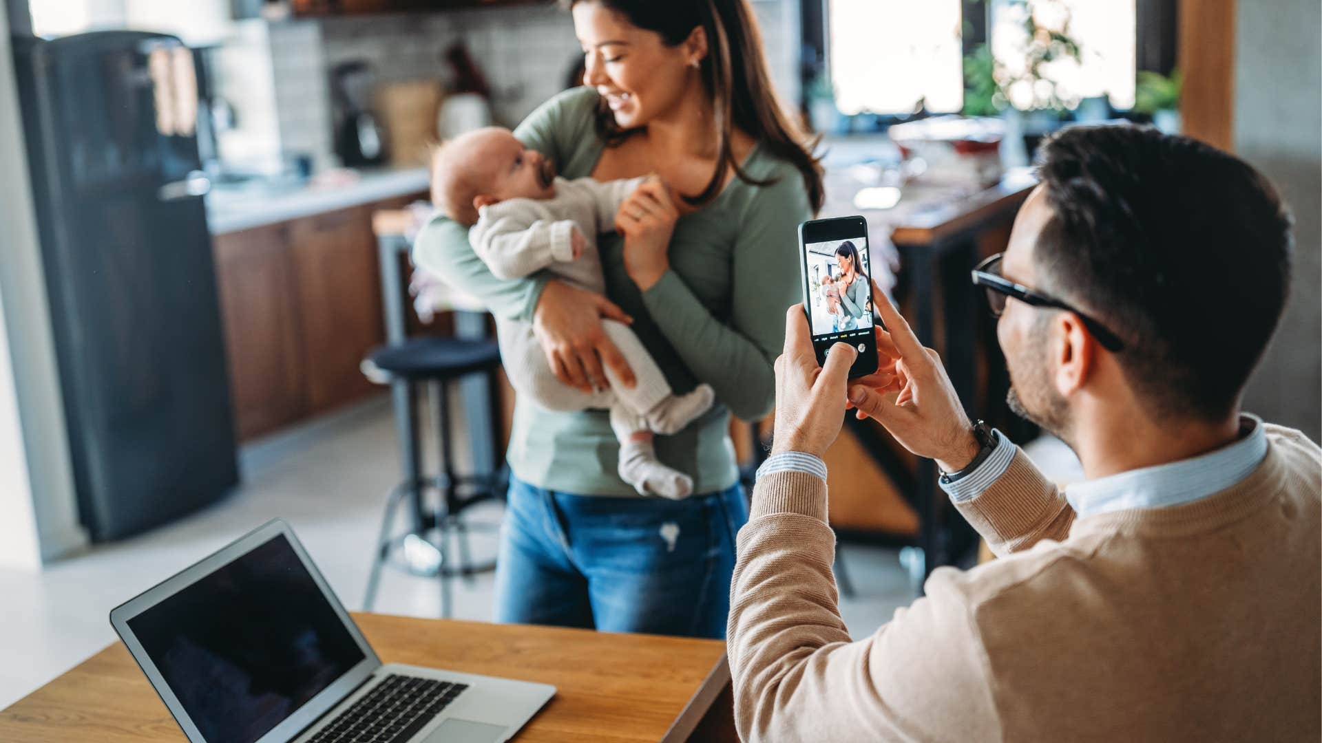 competitive parents taking photos of their newborn