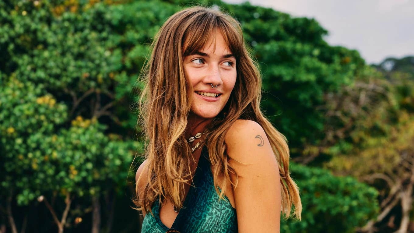 Thoughtful shy introverted woman smiling softly in nature, illustrating how highly introverted minds perceive things in ways that totally confuse others.