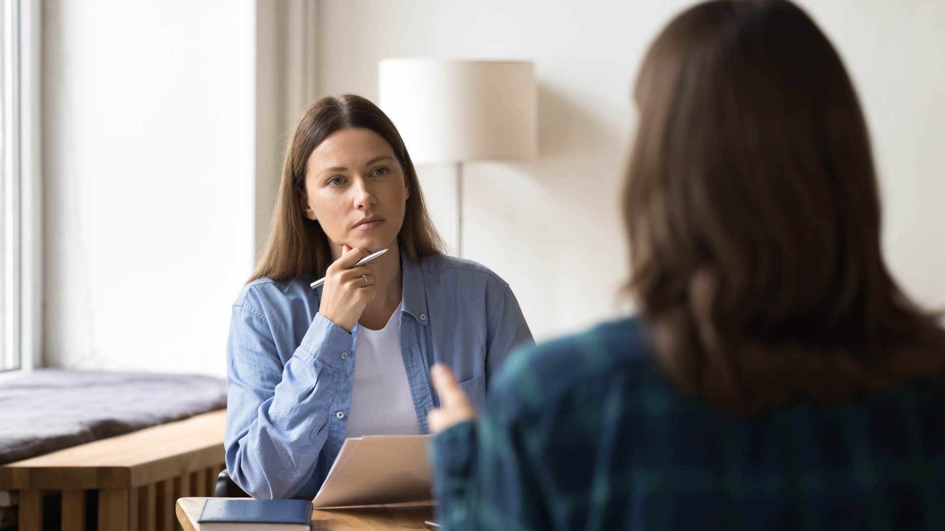 woman in blue sweater telling other woman you look tired