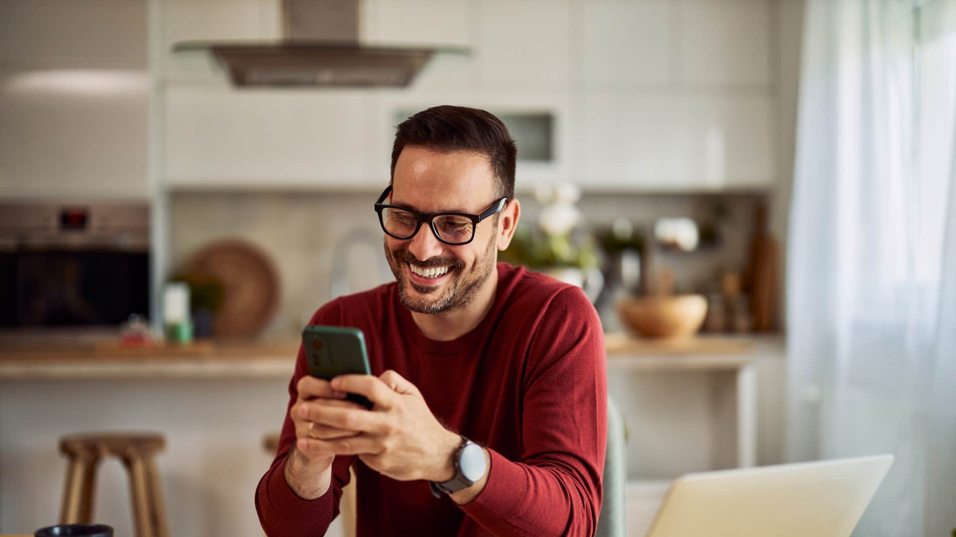 man smiling looking at his phone