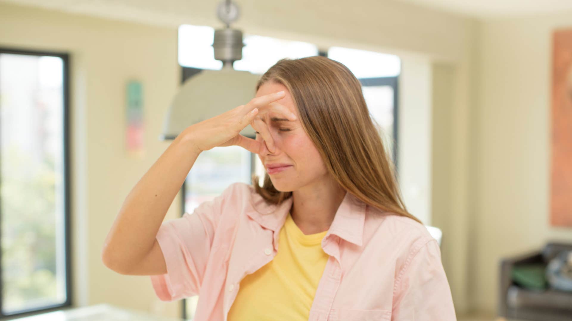 woman smelling something foul holding her nose