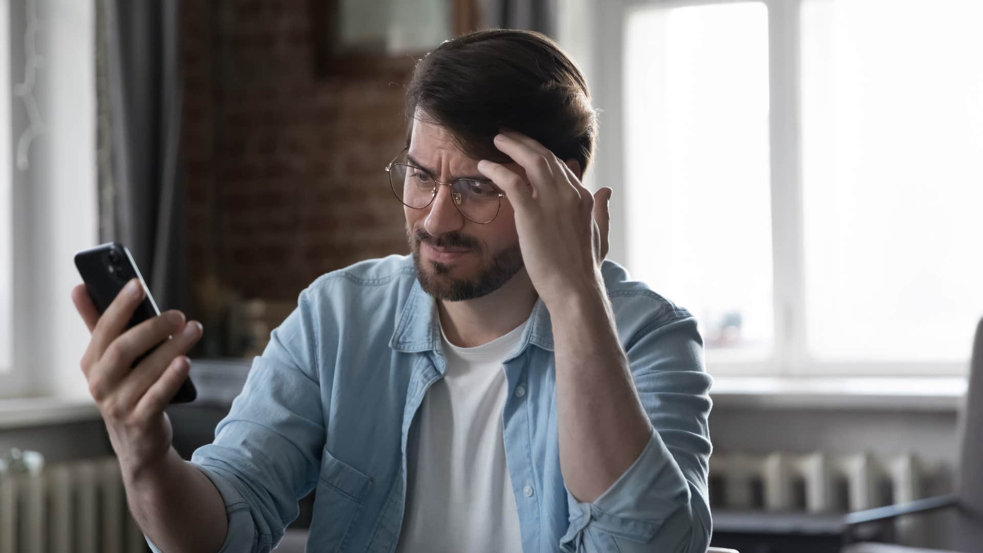man looking frustrated at phone as he believes you can't trust everything on the internet