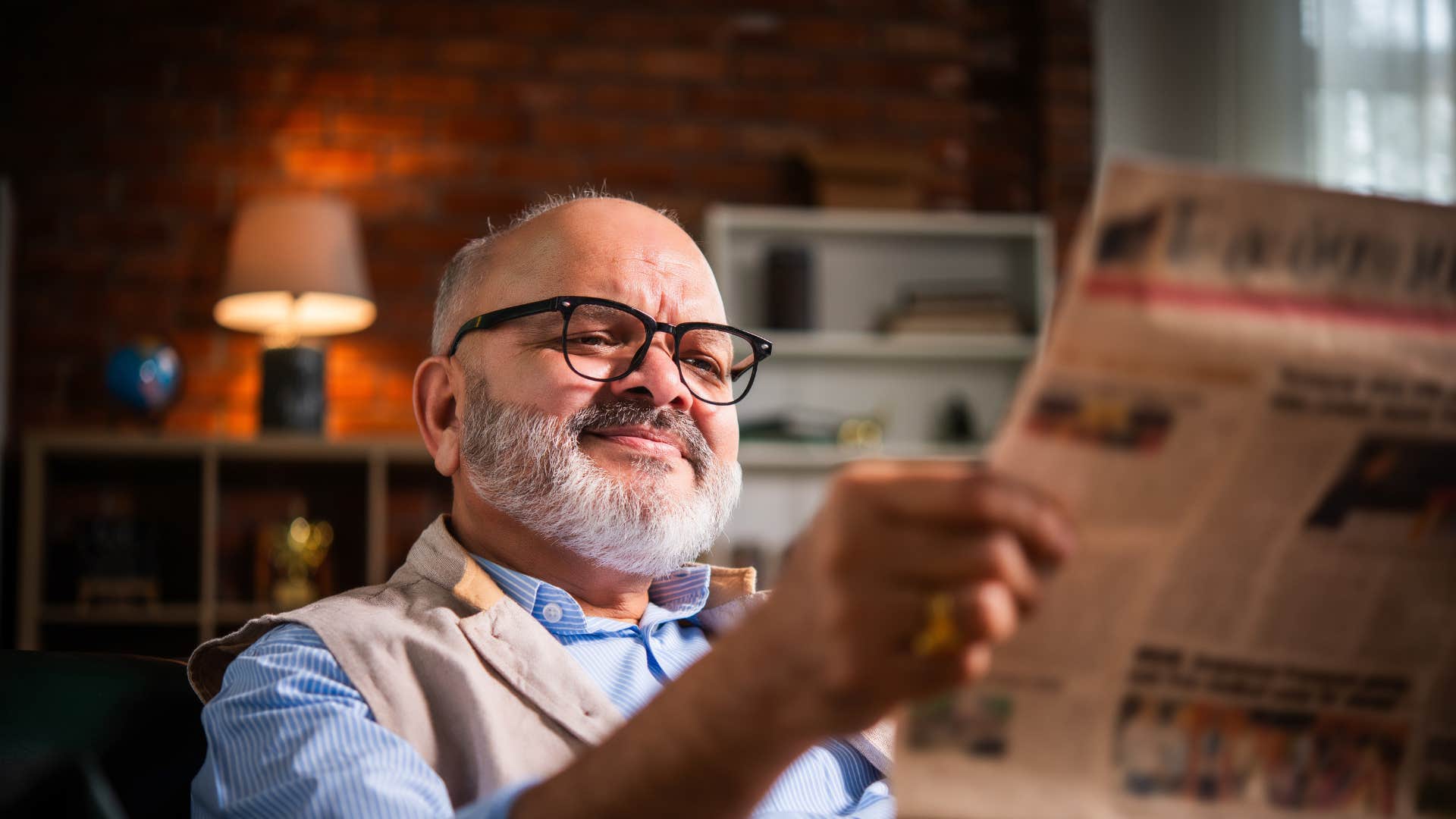 older man reading newspaper as he trusts in professional journalism