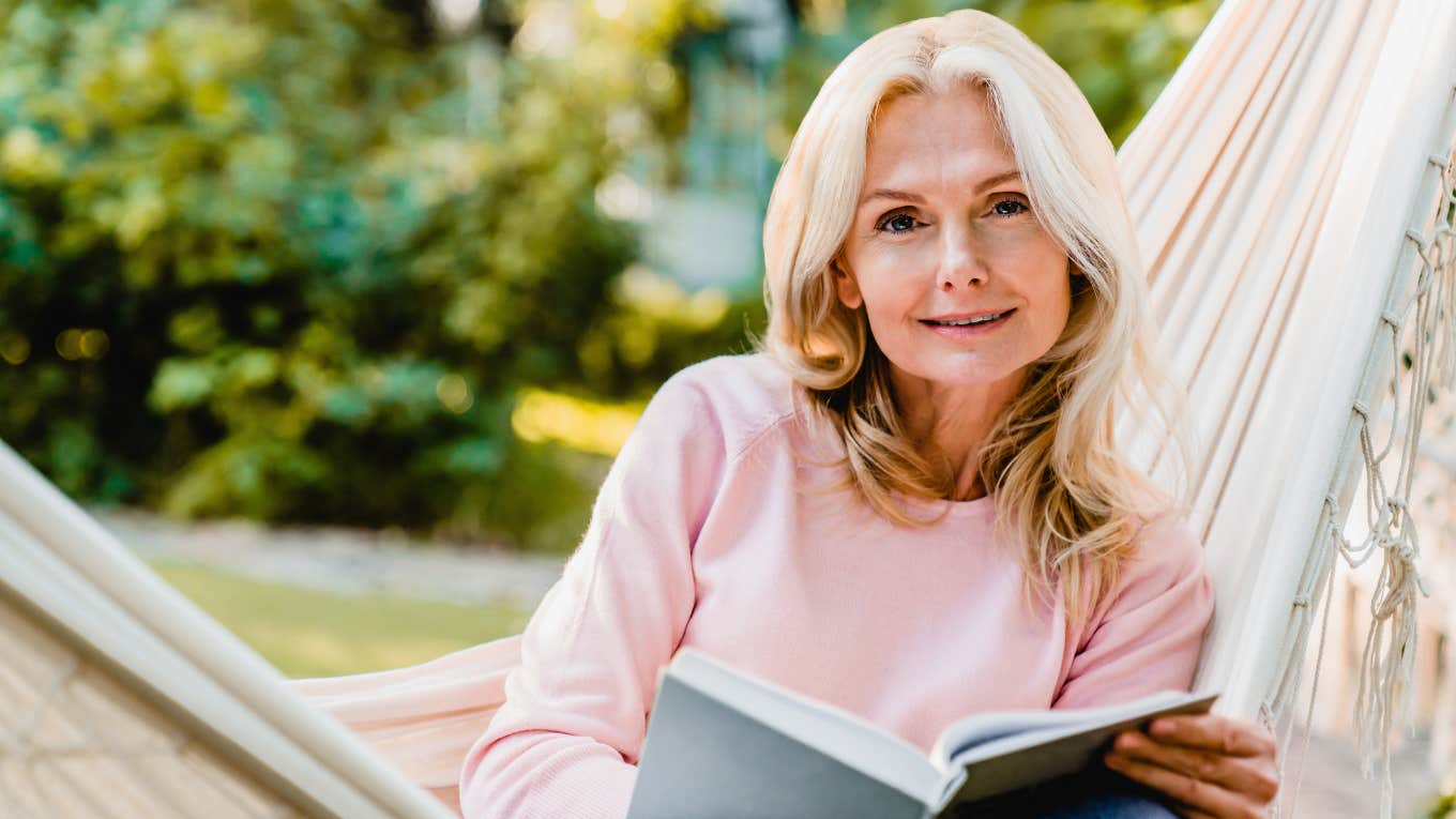older woman reading a book ignoring her phone