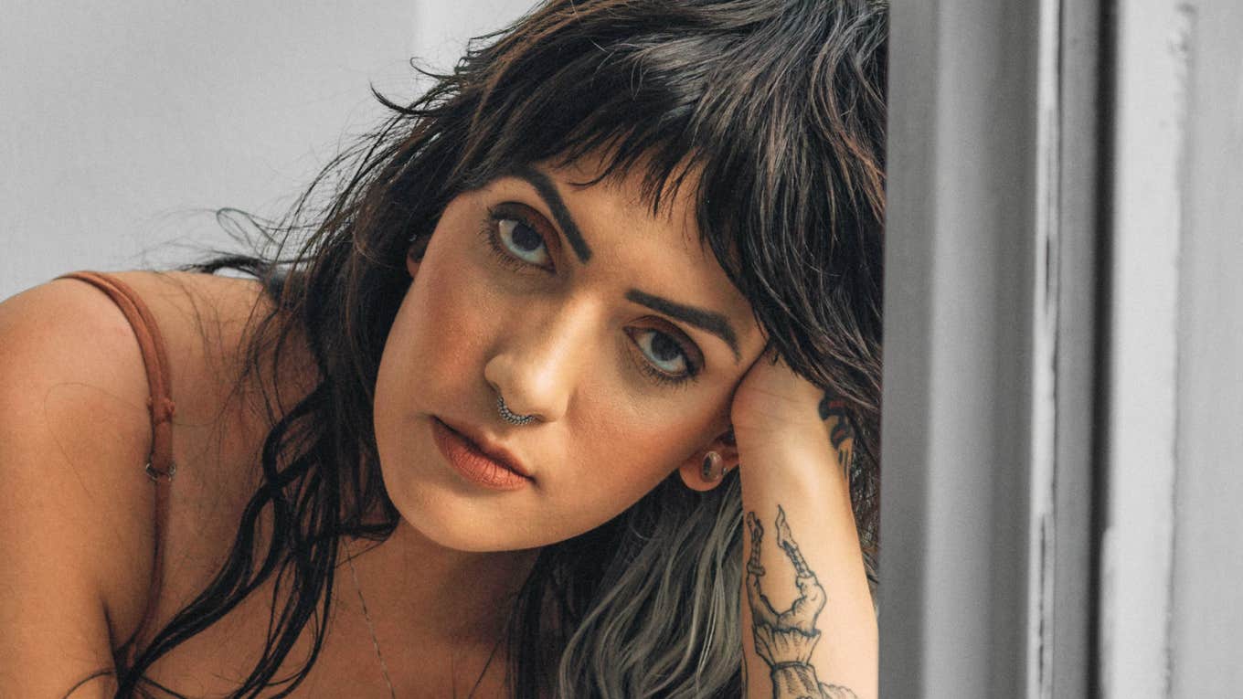 Person resting their head on their hand showing the subtle habits of people who secretly don’t want to be in a relationship