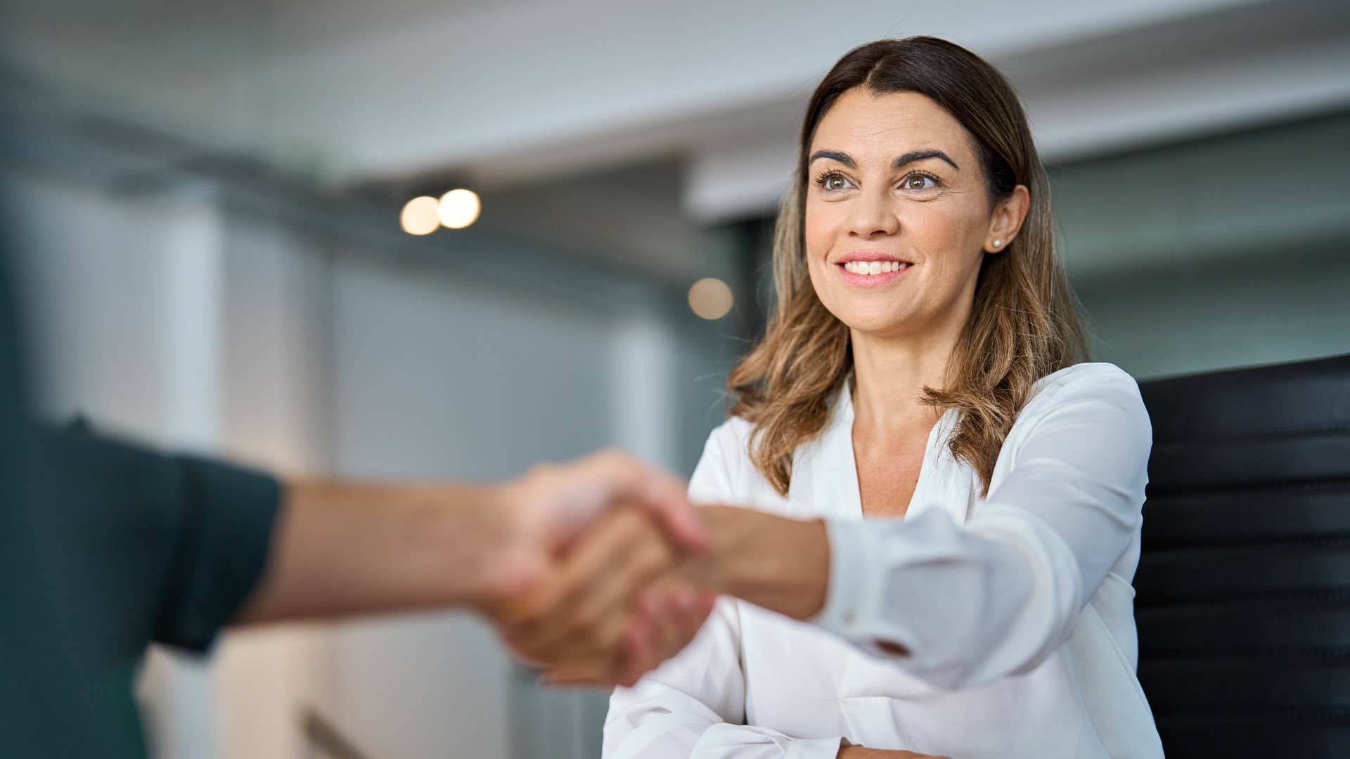 woman shaking hands with colleague building bridges instead of burning them