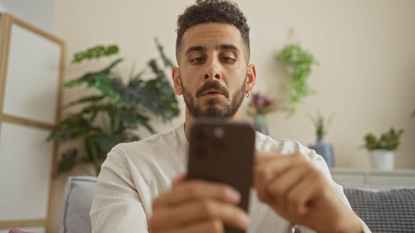 man looking at his phone with serious expression