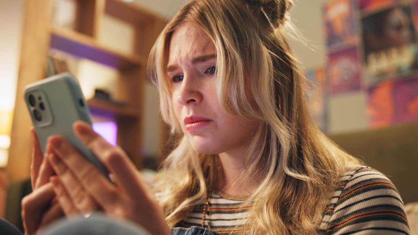 upset woman looking at her phone